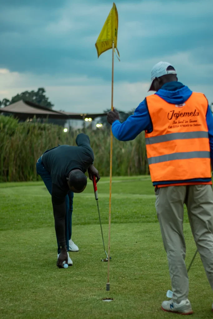 Golf in Kenya: a caddie and golfer reading a putt in Nairobi