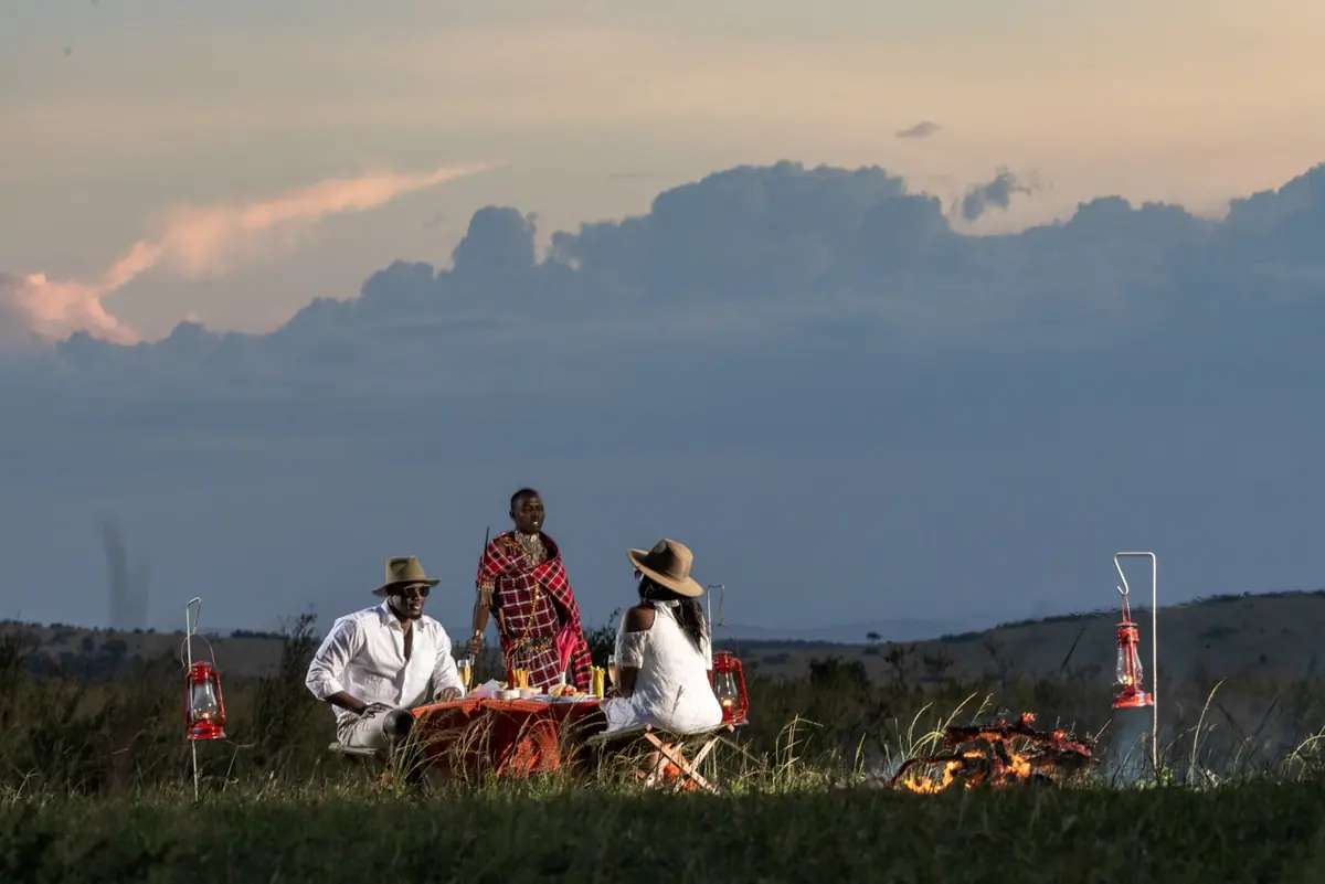 Guests with Maasai hosts at sunset in the Mara